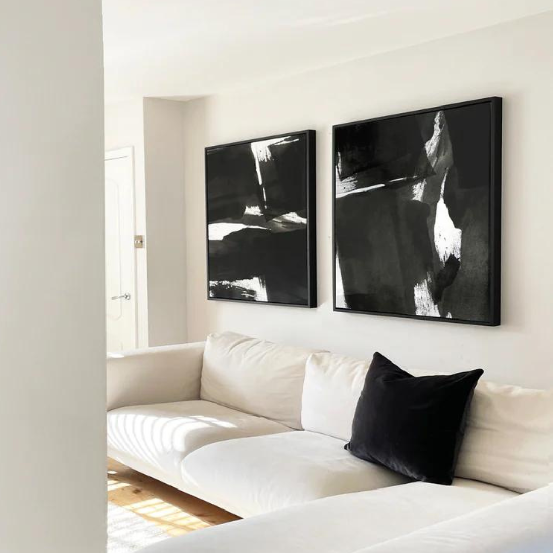Neutral room with two black and white abstract prints above the sofa