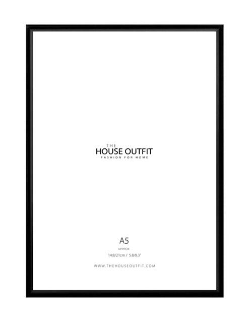A black rectangular picture frame with a white insert, centered on a white background. The insert includes printed text reading 'THE HOUSE OUTFIT', 'FASHION FOR HOME', 'A5', and a website at the bottom.