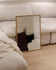 Modern interior with a black floor lamp, white sofa, and framed picture on a light wood floor.