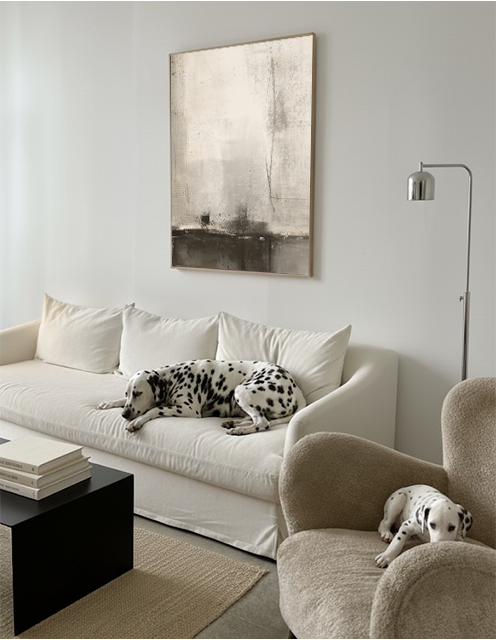 Two Dalmatian dogs in a modern living room with a white sofa and neutral decor.