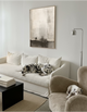 Two Dalmatian dogs in a modern living room with a white sofa and neutral decor.